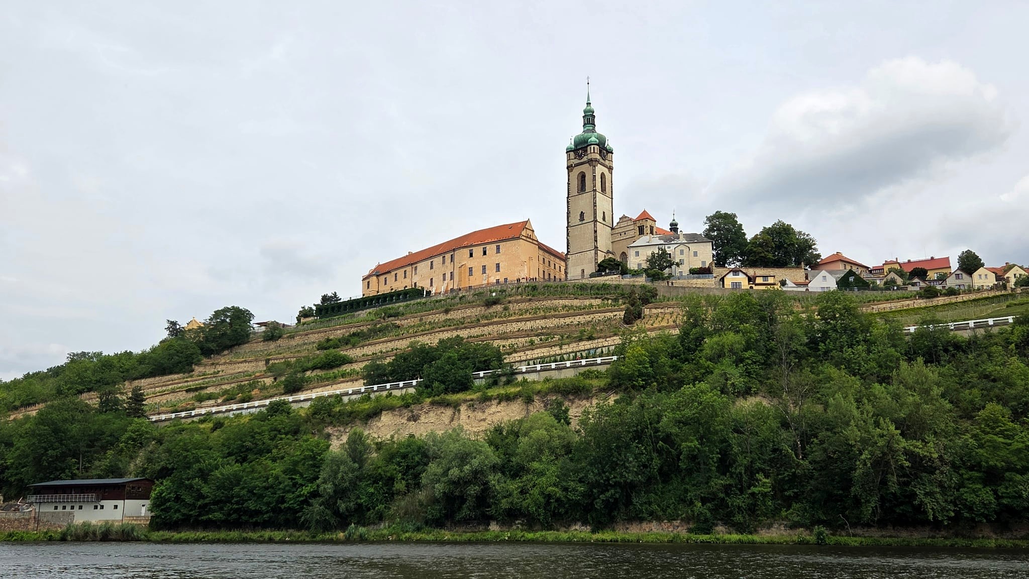 Pohled přes řeku na mělnický zámek, vinice a kostel svatých Petra a Pavla